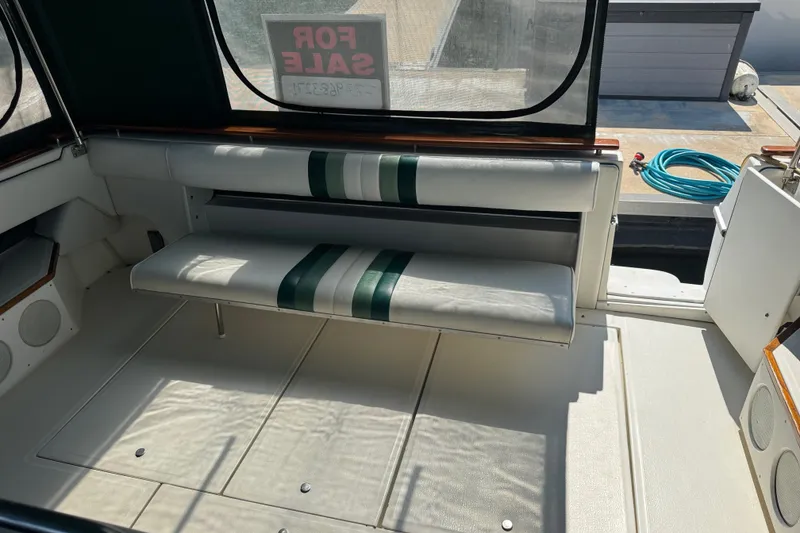 Slide: The Image of 1989 Sea Ray 300 Sundancer interior with white and green seating, "For Sale" sign visible. - 6