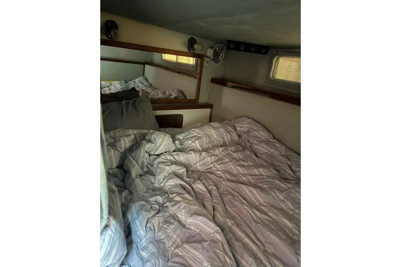 Slide: The Image of Cozy cabin interior of 1989 Sea Ray 300 Sundancer with striped bedding. - 11