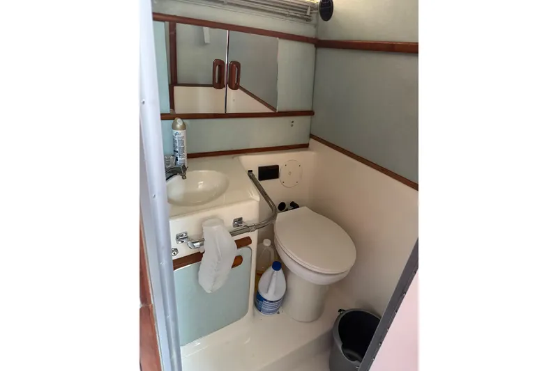 Slide: The Image of Compact bathroom in a 1989 Sea Ray 300 Sundancer boat, featuring sink and toilet. - 14