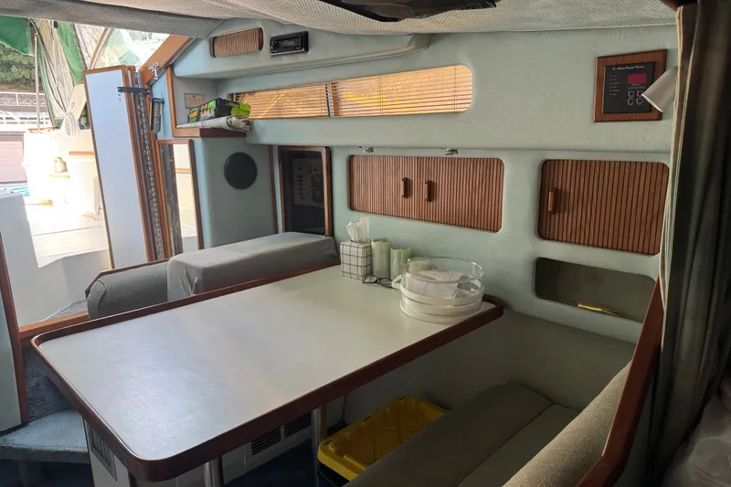Slide: The Image of Interior of 1989 Sea Ray 300 Sundancer boat with dining area and storage cabinets. - 17