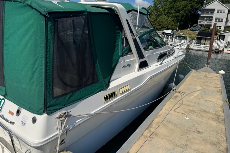 Slide: The Image of 1989 Sea Ray 300 Sundancer docked with green canopy, side view. - 5