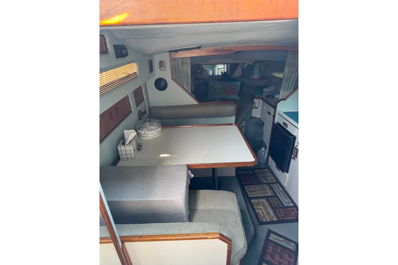 Slide: The Image of 1989 Sea Ray 300 Sundancer cabin interior with dining area and cozy seating. - 10