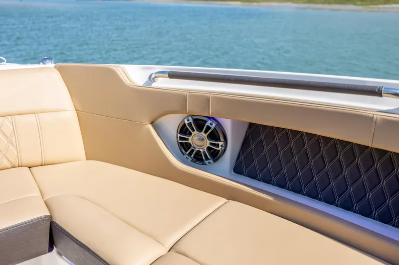 Slide: The Image of Luxurious seating on 2022 Sea Ray SLX 280 boat with speaker, overlooking serene water. - 18