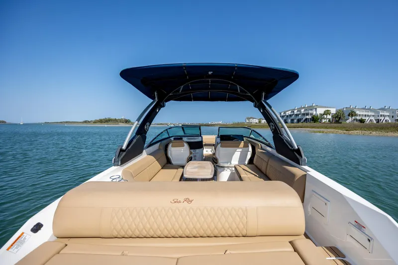 Slide: The Image of 2022 Sea Ray SLX 280 boat with tan seating and blue canopy on calm water. - 8