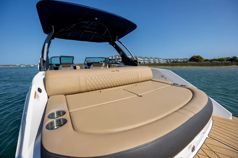 Slide: The Image of 2022 Sea Ray SLX 280 boat with luxurious seating and cup holders on a sunny day. - 9