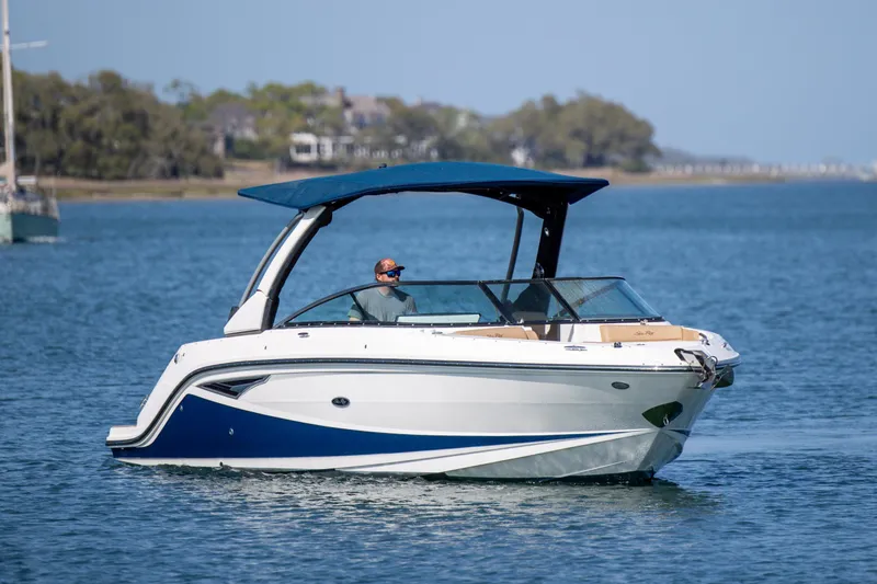 Slide: The Image of 2022 Sea Ray SLX 280 boat cruising on a calm lake under clear skies. - 2