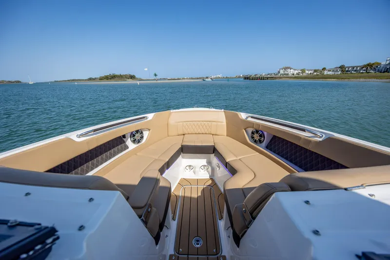 Slide: The Image of Luxurious 2022 Sea Ray SLX 280 boat interior with tan seating on calm water. - 17