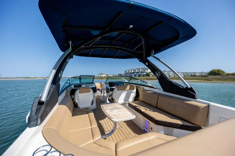 Slide: The Image of 2022 Sea Ray SLX 280 boat interior with luxurious seating and canopy on a sunny day. - 10