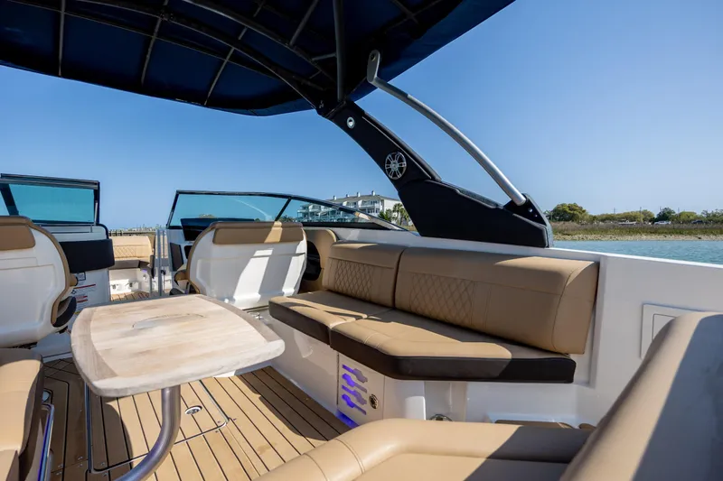 Slide: The Image of Luxurious interior of 2022 Sea Ray SLX 280 boat with tan seating and wooden table. - 11