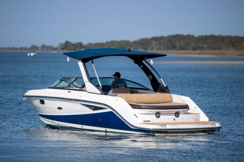 Slide: The Image of 2022 Sea Ray SLX 280 boat cruising on a serene lake with a blue canopy. - 6