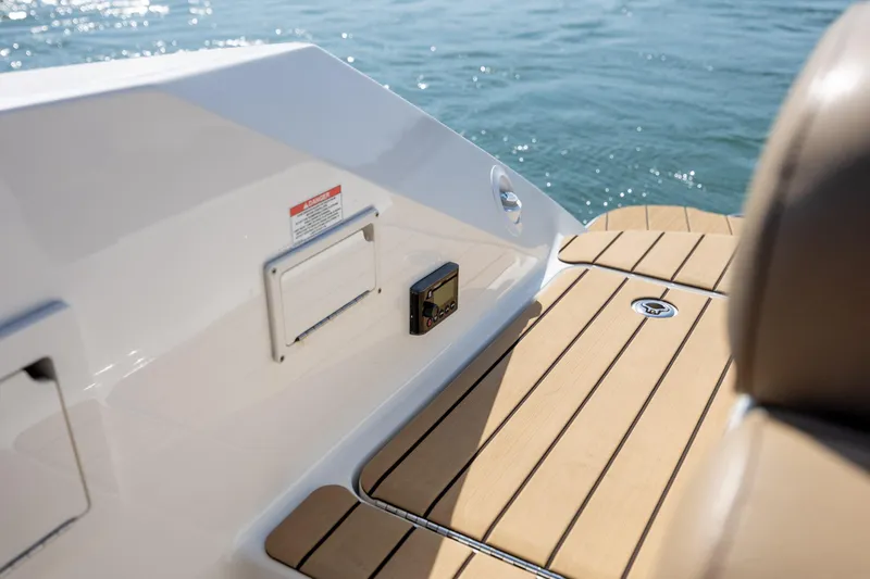 Slide: The Image of 2022 Sea Ray SLX 280 boat deck with teak flooring, near water. - 25