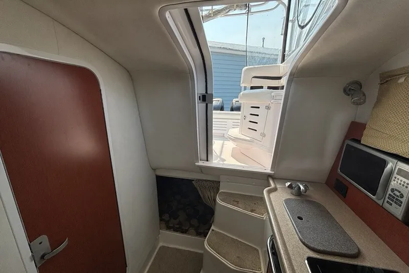 Slide: The Image of Interior view of 2007 Pro-Line 29 Express boat, featuring kitchenette and cabin door. - 14