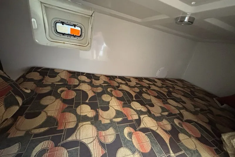 Slide: The Image of Cabin interior of 2007 Pro-Line 29 Express with patterned bedding and small window. - 13