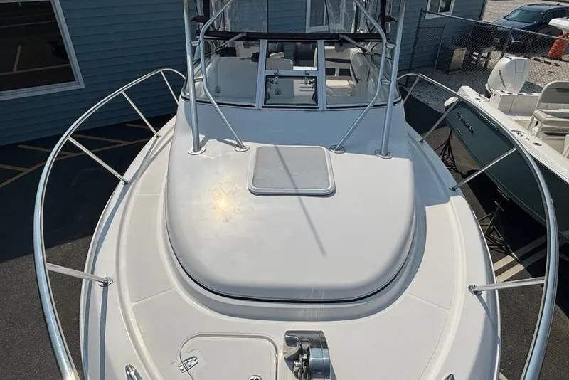 Slide: The Image of 2007 Pro-Line 29 Express boat deck with railing and hatch, docked near other boats. - 16