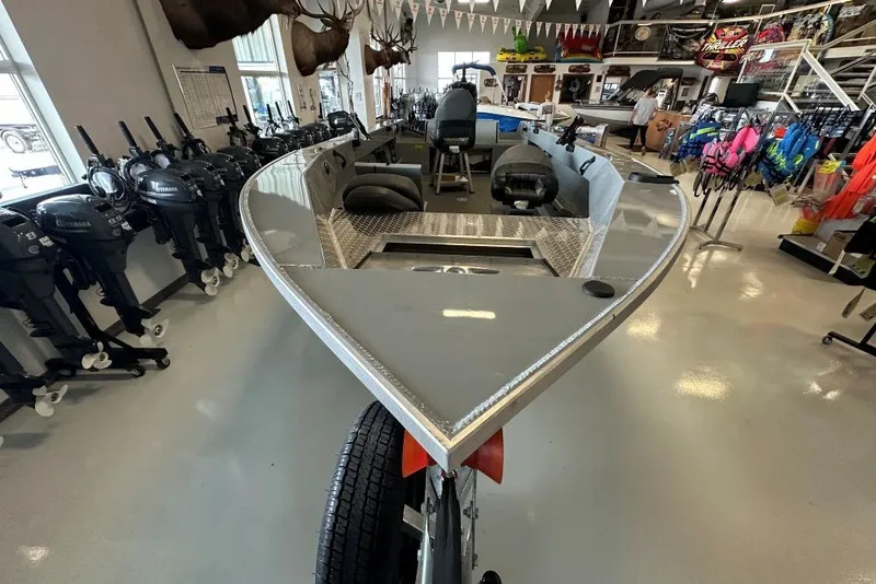 Slide: The Image of 2026 Hewescraft 180 Open Fisherman boat displayed in a showroom with equipment. - 2