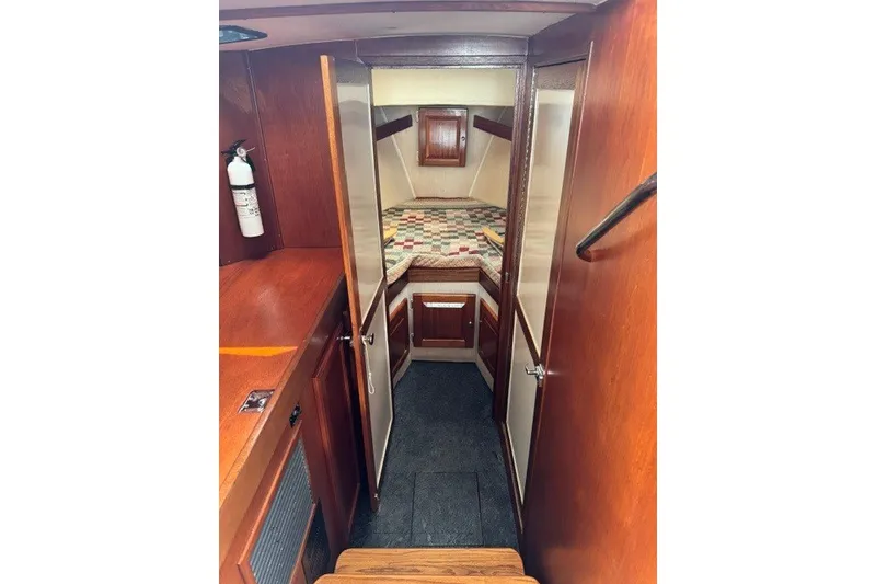 Slide: The Image of Cozy cabin interior of 2001 Willis Beal 31 boat with wood finish and quilted bed. - 15