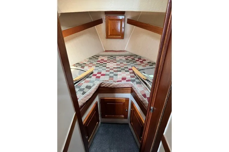 Slide: The Image of Cozy cabin interior of 2001 Willis Beal 31 boat with quilted bedding and wooden cabinetry. - 19
