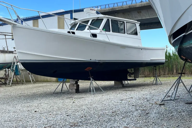Slide: The Image of White Willis Beal 31 boat from 2001 on stands in a boatyard. - 26