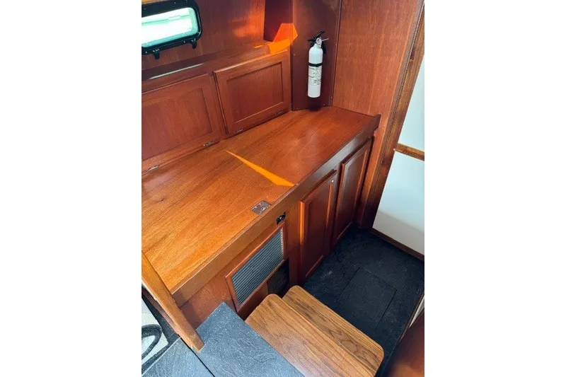 Slide: The Image of Wooden interior of 2001 Willis Beal 31 boat with cabinets and fire extinguisher. - 16