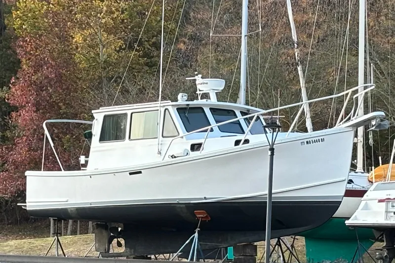 Slide: The Image of White 2001 Willis Beal 31 boat on land, surrounded by autumn trees. - 24