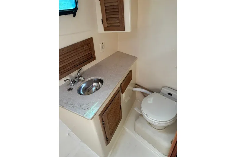 Slide: The Image of Compact boat bathroom with sink and toilet, featuring wooden cabinetry, Willis Beal 31, 2001 model. - 18