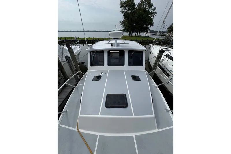 Slide: The Image of 2001 Willis Beal 31 boat docked, showcasing sleek design and spacious deck. - 3
