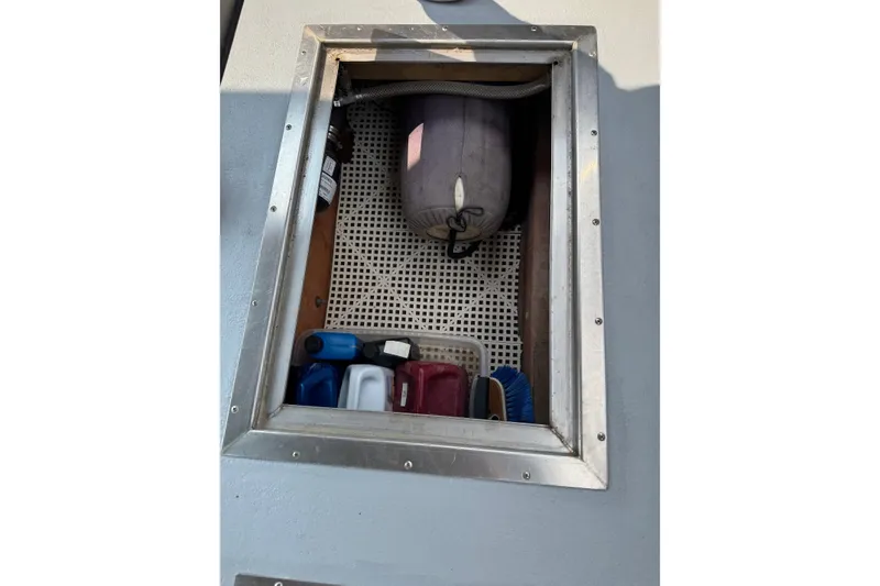 Slide: The Image of Storage compartment on a 2001 Willis Beal 31 boat with various supplies and equipment. - 6