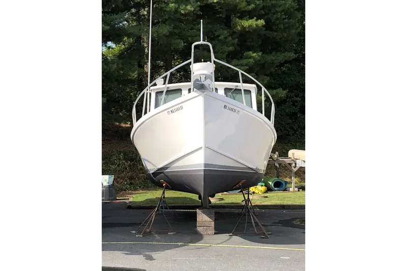 Slide: The Image of Front view of a 2001 Willis Beal 31 boat on stands, surrounded by greenery. - 27