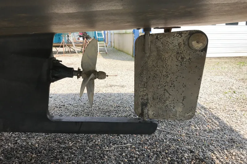 Slide: The Image of Close-up of a 2001 Willis Beal 31 boat propeller and rudder on gravel. - 29