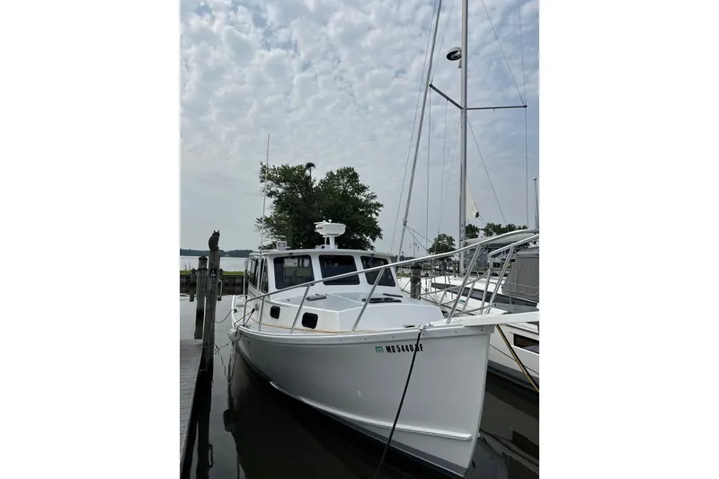 The Image of 2001 Willis Beal 31 boat docked under cloudy sky, featuring sleek white design. - 0
