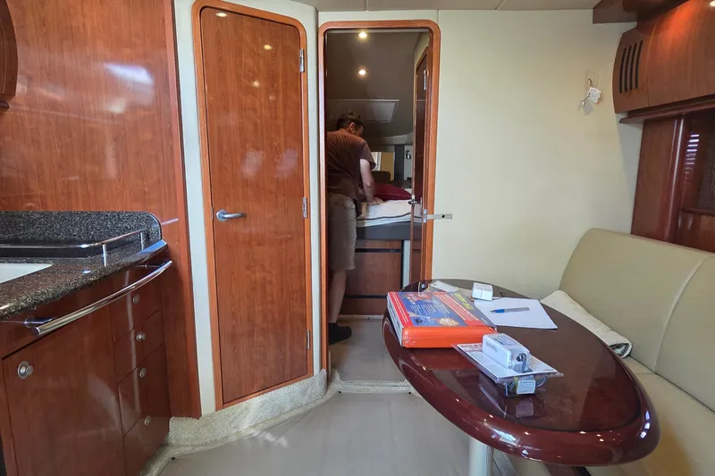 Slide: The Image of Interior of a 2004 Sea Ray 380 Sundancer yacht with wood finishes and a cozy cabin. - 18