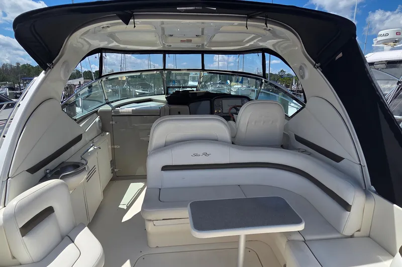Slide: The Image of 2004 Sea Ray 380 Sundancer interior with white seating and helm, docked at marina. - 29