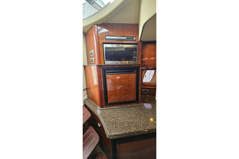 Slide: The Image of Luxurious 2004 Sea Ray 380 Sundancer yacht interior with wood cabinetry and modern appliances. - 10