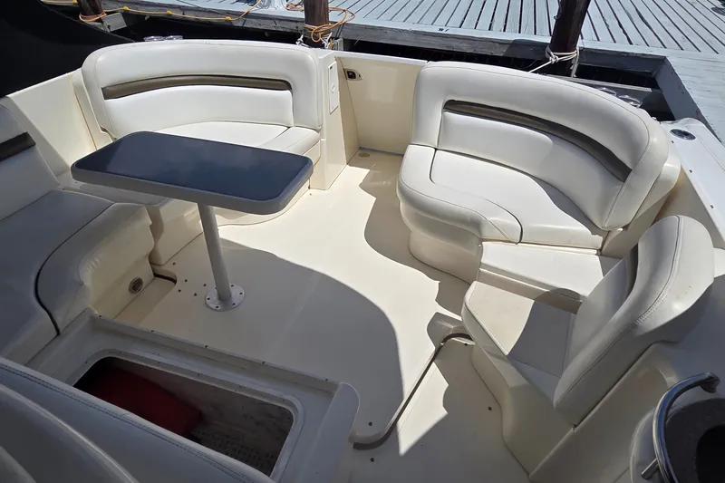 Slide: The Image of 2004 Sea Ray 380 Sundancer boat interior with white seating and a central table. - 25