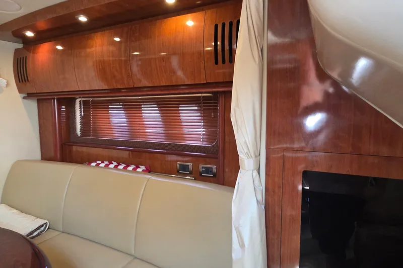 Slide: The Image of Interior of 2004 Sea Ray 380 Sundancer with wood paneling and beige seating. - 17
