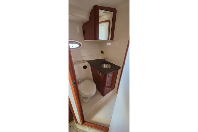 Slide: The Image of Compact bathroom in 2004 Sea Ray 380 Sundancer yacht with sink and toilet. - 19