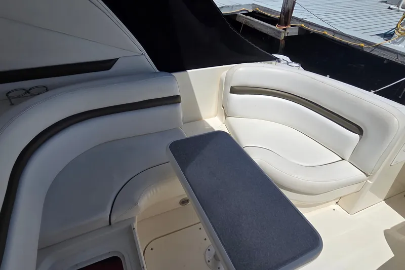 Slide: The Image of Interior seating area of 2004 Sea Ray 380 Sundancer yacht with cushioned seats and table. - 26
