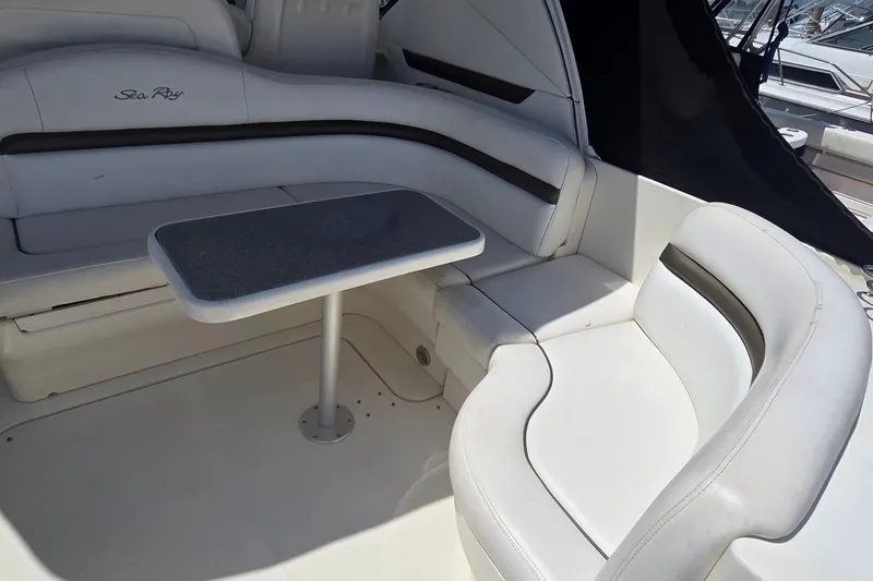 Slide: The Image of 2004 Sea Ray 380 Sundancer interior with white seating and a small table. - 27