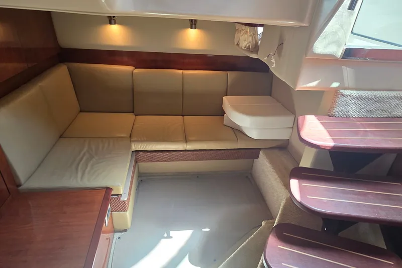 Slide: The Image of Interior of 2004 Sea Ray 380 Sundancer yacht with beige seating and wooden accents. - 16