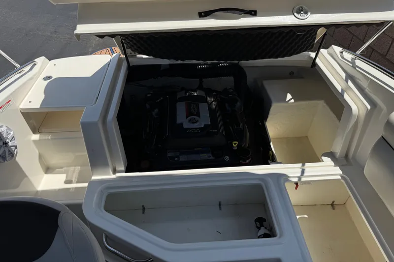 Slide: The Image of 2019 Bayliner 195 Deck Boat engine compartment with open storage areas. - 18