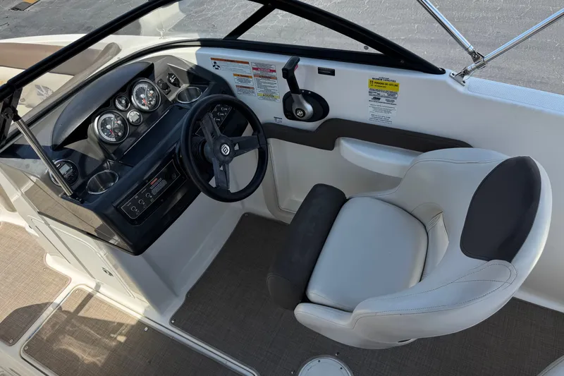 Slide: The Image of 2019 Bayliner 195 Deck Boat cockpit with steering wheel, gauges, and comfortable seating. - 26