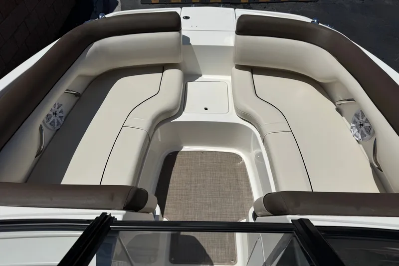Slide: The Image of 2019 Bayliner 195 Deck Boat interior with beige seating and brown accents. - 13