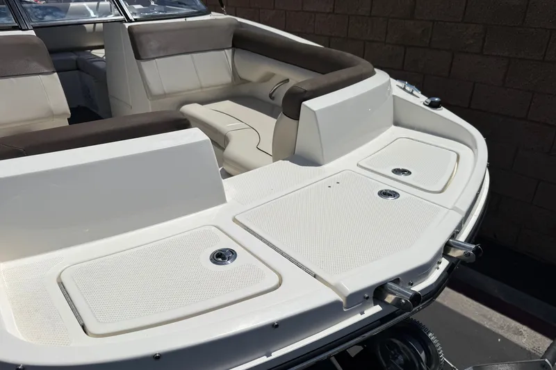 Slide: The Image of 2019 Bayliner 195 Deck Boat interior with cushioned seating and storage compartments. - 10