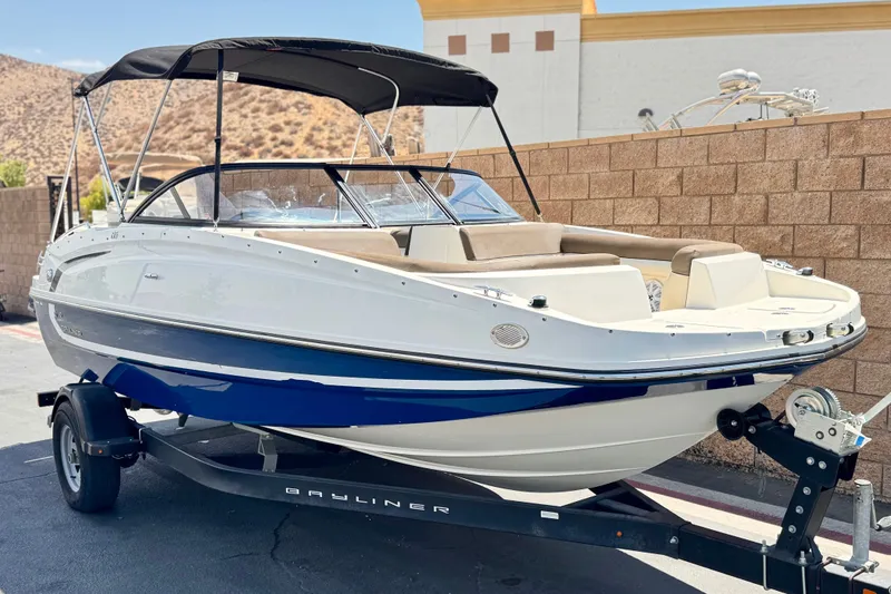Slide: The Image of 2019 Bayliner 195 Deck Boat on trailer, parked outdoors. - 1