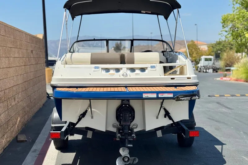 Slide: The Image of 2019 Bayliner 195 Deck Boat on trailer, rear view, parked outdoors. - 4
