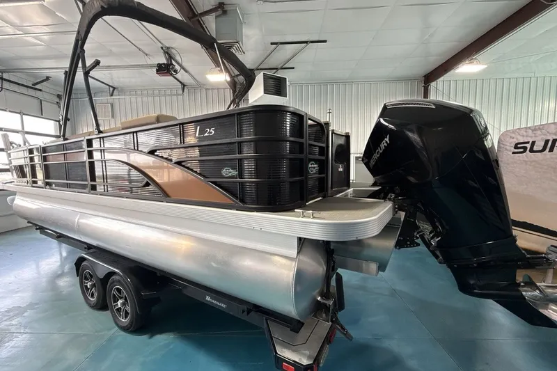 Slide: The Image of 2022 Bennington 25 LSAPG pontoon boat with Mercury outboard motor in showroom. - 3
