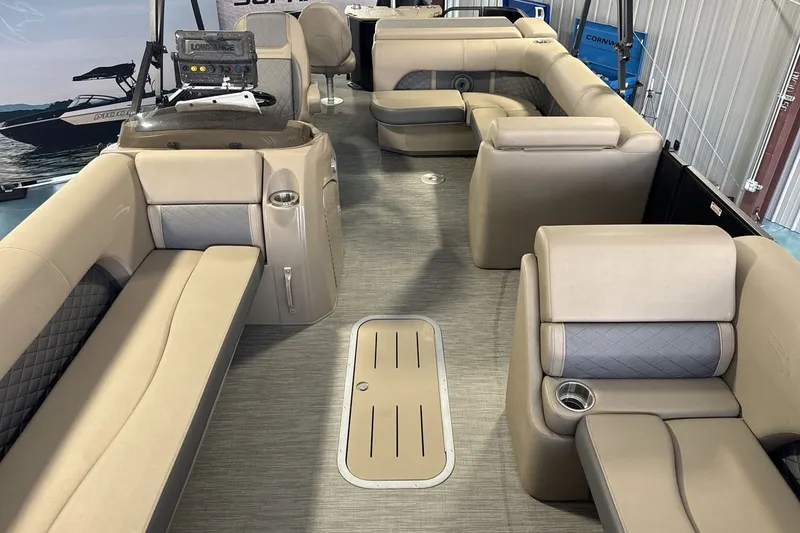 Slide: The Image of 2022 Bennington 25 LSAPG pontoon boat interior with beige seating and modern dashboard. - 12