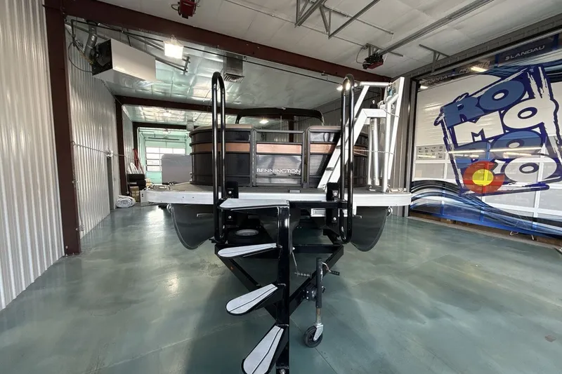 Slide: The Image of 2022 Bennington 25 LSAPG pontoon boat in a spacious indoor showroom. - 8