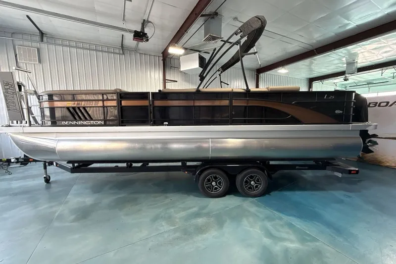 Slide: The Image of 2022 Bennington 25 LSAPG pontoon boat on trailer in indoor showroom. - 2