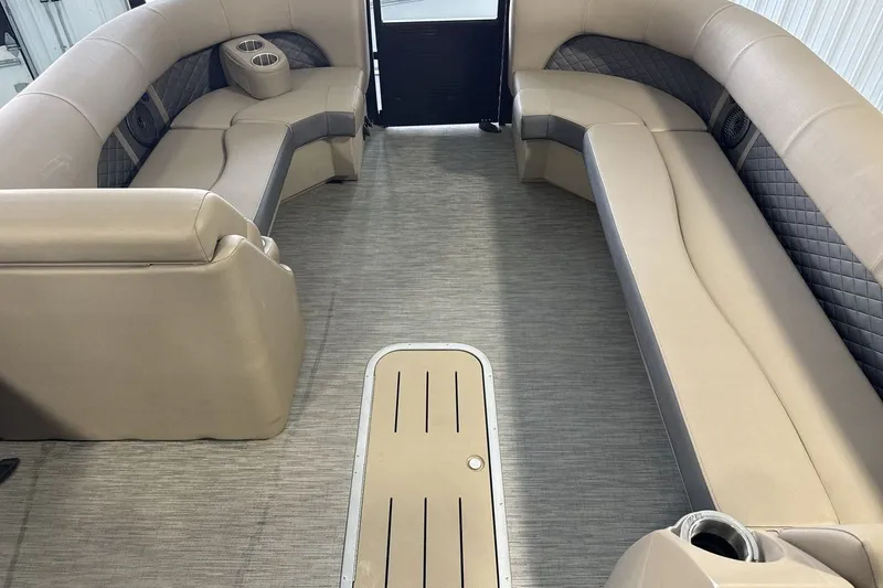 Slide: The Image of Interior of a 2022 Bennington 25 LSAPG pontoon boat with beige seating and cup holders. - 11
